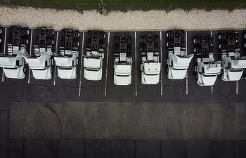fleet of white 18 wheeler semi trucks overhead view drone photography